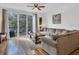 Comfortable living room with wood floors, a large sofa, and sliding glass doors to a balcony at 3106 Bayshore Oaks Dr, Tampa, FL 33611