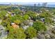 Aerial view of a lush, green residential neighborhood with mature trees, and Tampa Bay in the distance at 3115 W Fair Oaks Ave, Tampa, FL 33611