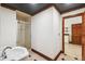 Bathroom featuring tiled shower, pedestal sink, dark patterned ceiling and wooden door at 3115 W Fair Oaks Ave, Tampa, FL 33611