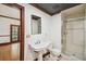 Functional bathroom with a tiled shower, pedestal sink, and neutral color scheme, and a door to another area at 3115 W Fair Oaks Ave, Tampa, FL 33611