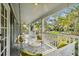 Extended view of the home's porch, complete with swing, white furniture and well manicured yard at 3115 W Fair Oaks Ave, Tampa, FL 33611