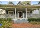 Inviting front porch featuring classic columns, a brick pathway, and a cozy seating area at 3115 W Fair Oaks Ave, Tampa, FL 33611