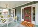 Close-up of the inviting front porch featuring a ceiling fan, a swing, and a 'hello' welcome mat at 3115 W Fair Oaks Ave, Tampa, FL 33611