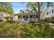Well-manicured lawn and mature trees surrounding a lovely two-story house with a welcoming porch at 3115 W Fair Oaks Ave, Tampa, FL 33611