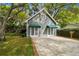 Exterior of garage with two white doors and green awnings, surrounded by lush landscaping at 3115 W Fair Oaks Ave, Tampa, FL 33611