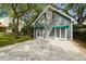 Exterior of garage featuring green awnings, lush landscaping, and a concrete driveway at 3115 W Fair Oaks Ave, Tampa, FL 33611
