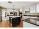 Gourmet kitchen with a large center island, stainless appliances and white cabinetry with dark countertops at 3115 W Fair Oaks Ave, Tampa, FL 33611