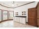 Bright laundry room with white cabinetry, dark countertop, and view of the yard through shuttered windows at 3115 W Fair Oaks Ave, Tampa, FL 33611