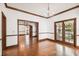 Open-concept living room with beautiful hardwood floors, decorative molding, chandelier, and French doors to a patio at 3115 W Fair Oaks Ave, Tampa, FL 33611
