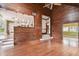 Hardwood floors complement wood paneled walls in the open living room concept featuring a pass through to the kitchen at 3115 W Fair Oaks Ave, Tampa, FL 33611