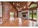 A spacious living room boasts wood walls, hardwood floors, and a stone fireplace for a cozy, rustic ambiance at 3115 W Fair Oaks Ave, Tampa, FL 33611