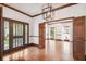 Bright living room with hardwood floors, wood trim, chandelier and views of the front yard through french doors at 3115 W Fair Oaks Ave, Tampa, FL 33611