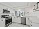 Modern kitchen with stainless steel appliances, sleek white cabinetry, and quartz countertops at 3248 Rock Valley Dr, Holiday, FL 34691