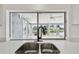 Kitchen sink with matte black faucet and large window view of the backyard at 3248 Rock Valley Dr, Holiday, FL 34691