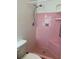 Bathroom view highlighting a tiled pink shower with a shower head, seat, and a small corner shelf at 4550 Plaza Way, St Pete Beach, FL 33706