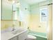 Bathroom features a vanity with sink, toilet, bathtub with shower, yellow tiling and a window at 4550 Plaza Way, St Pete Beach, FL 33706