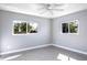 Sun-filled bedroom with grey floors, light walls, and a ceiling fan at 4550 Plaza Way, St Pete Beach, FL 33706