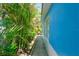 Exterior of home showing walkway, colorful wall and surrounding tropical vegetation and palm trees at 4550 Plaza Way, St Pete Beach, FL 33706