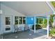 Inviting covered front porch with tiled floor and seating area outside the front door at 4550 Plaza Way, St Pete Beach, FL 33706
