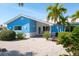 Beautifully landscaped front yard of a blue home with tropical foliage and gravel at 4550 Plaza Way, St Pete Beach, FL 33706