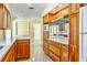 Open kitchen area with natural wood cabinets and shelves, stone countertops, and stainless appliances at 4550 Plaza Way, St Pete Beach, FL 33706