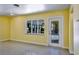 Bright living room with yellow walls, large windows, and a view of tropical landscaping at 4550 Plaza Way, St Pete Beach, FL 33706