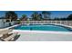 Sparkling community pool with ample seating, surrounded by a white fence and lush landscaping, perfect for relaxation and recreation at 4560 Overlook Ne Dr # 163, St Petersburg, FL 33703