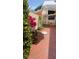 Outdoor patio featuring vibrant plants, colorful umbrella, swing chair, and brick flooring at 468 Boca Ciega Point S Blvd, St Petersburg, FL 33708