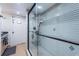 Shower with custom tile and a glass door, accented by decorative tiles and black hardware at 4937 Dover Ne St, St Petersburg, FL 33703