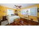 Comfortable bedroom featuring wood floors, a ceiling fan, and windows with plantation shutters at 4937 Dover Ne St, St Petersburg, FL 33703