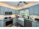 Charming kitchen with stainless steel appliances, white subway tile, gray cabinets, and granite countertops at 4937 Dover Ne St, St Petersburg, FL 33703