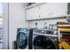 Laundry room featuring side-by-side Samsung washer and dryer sets and overhead storage at 4937 Dover Ne St, St Petersburg, FL 33703
