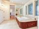 Bathroom with a soaking tub, decorative windows, and mirrored wall at 5020 S Shore Crest Cir, Tampa, FL 33609