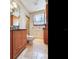 A cozy bathroom features travertine flooring, wood cabinets and a window at 5020 S Shore Crest Cir, Tampa, FL 33609