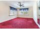 Bright bedroom with red carpet, crown moulding, ceiling fan, and two windows at 5020 S Shore Crest Cir, Tampa, FL 33609