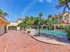 Luxury property showcasing an expansive pool, red brick walkway, and lush palm trees at 5020 S Shore Crest Cir, Tampa, FL 33609
