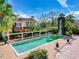 A beautiful mediterranean-style house boasts a refreshing pool surrounded by lush greenery and brick paved outdoor areas at 5020 S Shore Crest Cir, Tampa, FL 33609
