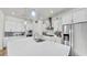 Modern white kitchen featuring stainless steel appliances, island and ample counter space at 5317 Del Coronado Dr, Apollo Beach, FL 33572