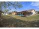 Expansive backyard view showcasing a screened-in pool and ample green space surrounded by trees and fencing at 5357 Kirkwood Ave, Spring Hill, FL 34608