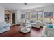 Bright living room featuring hardwood floors, comfortable seating, and large windows at 5357 Kirkwood Ave, Spring Hill, FL 34608