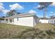 A view of the backyard with a white privacy fence and a glimpse of the home's exterior at 6202 Belkton Ave, Spring Hill, FL 34608