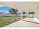 A covered patio overlooks the expansive backyard enclosed by a privacy fence at 6202 Belkton Ave, Spring Hill, FL 34608