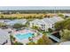 Aerial view of condo complex with a pool, hot tub, tennis court, and manicured landscaping at 6916 Stonesthrow N Cir # 9103, St Petersburg, FL 33710