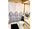 Cozy bathroom with patterned shower curtain, tiled floor, sink vanity, and toilet with décor at 6916 Stonesthrow N Cir # 9103, St Petersburg, FL 33710