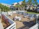 View of deck with tables, chairs, lounge chairs and landscaping at 6916 Stonesthrow N Cir # 9103, St Petersburg, FL 33710