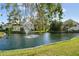 Exterior view showcasing waterfront condos, lush landscaping, and tranquil lake with fountain at 6916 Stonesthrow N Cir # 9103, St Petersburg, FL 33710