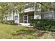 View of condo with screened porch overlooking lawn and mature shrubs at 6916 Stonesthrow N Cir # 9103, St Petersburg, FL 33710