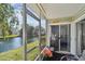 Charming enclosed lanai featuring water views, a ceiling fan, and a cozy seating area at 6916 Stonesthrow N Cir # 9103, St Petersburg, FL 33710