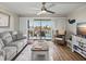 Cozy living room featuring wood-look floors, sliding shutters to balcony, and stylish furnishings at 7600 Sun Island S Dr # 703, South Pasadena, FL 33707