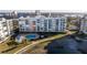 Scenic aerial view featuring a pool, modern building, lush landscaping, and waterfront access at 7902 Sailboat Key S Blvd # 206, South Pasadena, FL 33707